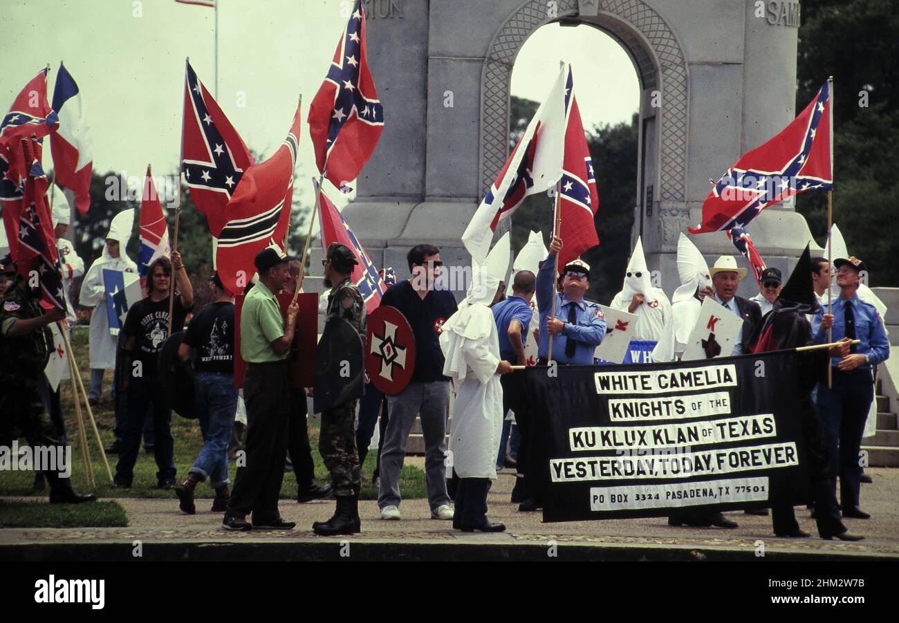 Houston Texas USA, 1990: Membri del gruppo supremacista bianco Ku Klux Klan marzo centro portando bandiere confederate. ©Bob Daemmrich Foto Stock