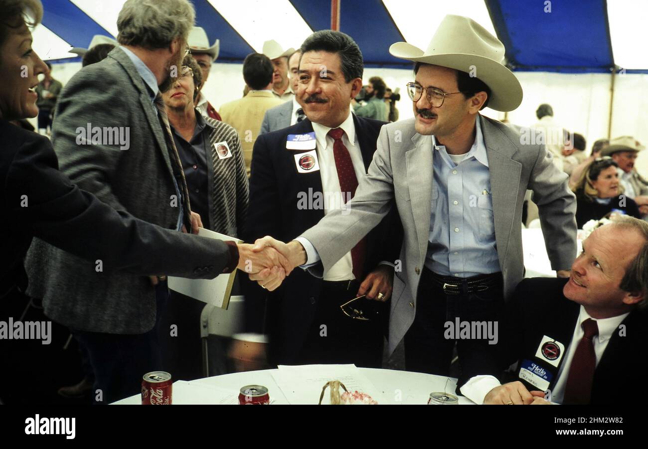 Austin Texas USA: Il commissario per l'agricoltura del Texas Jim Hightower (in cappello) scuote le mani con un ben più grande. ©Bob Daemmrich Foto Stock