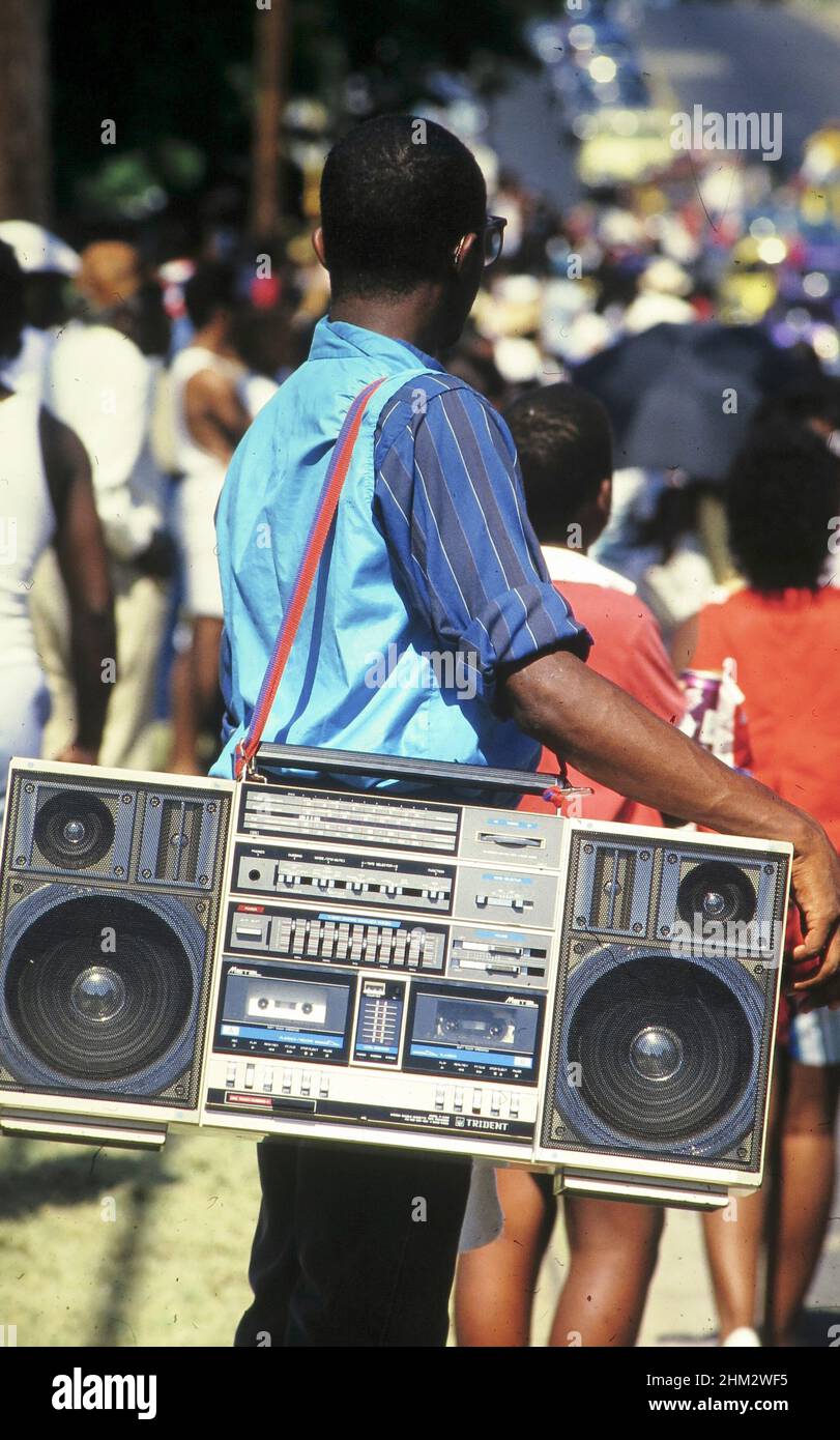 Austin, Texas USA, giugno 1989: Il giovane uomo nero porta un grande 'boombox' su una tracolla mentre si guarda una sfilata. ©Bob Daemmrich Foto Stock