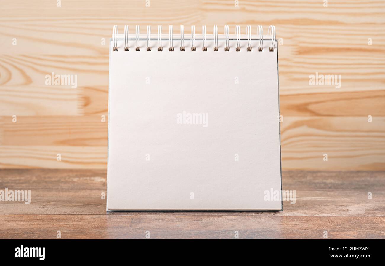 Mockup blocco note vuoto su sfondo di legno. Il bianco della brochure è su una scrivania di legno. Modello per il tuo progetto. Scrivania con calendario Foto Stock