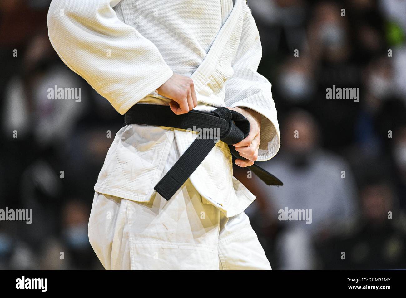 L'immagine mostra un combattente judoka/judo che ripone la cintura nera sul  suo judogi/kimono bianco durante il Grand Slam di Parigi 2022, IJF World  JudoTour il 6 febbraio 2022 presso l'Accor Arena di