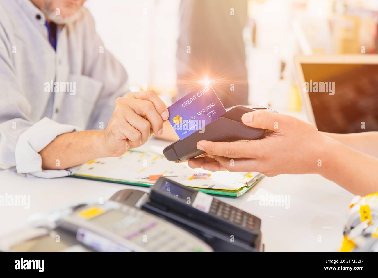 Clienti che utilizzano il sistema di pagamento con carta di credito per transazioni di denaro per l'acquisto di prodotti. Foto Stock