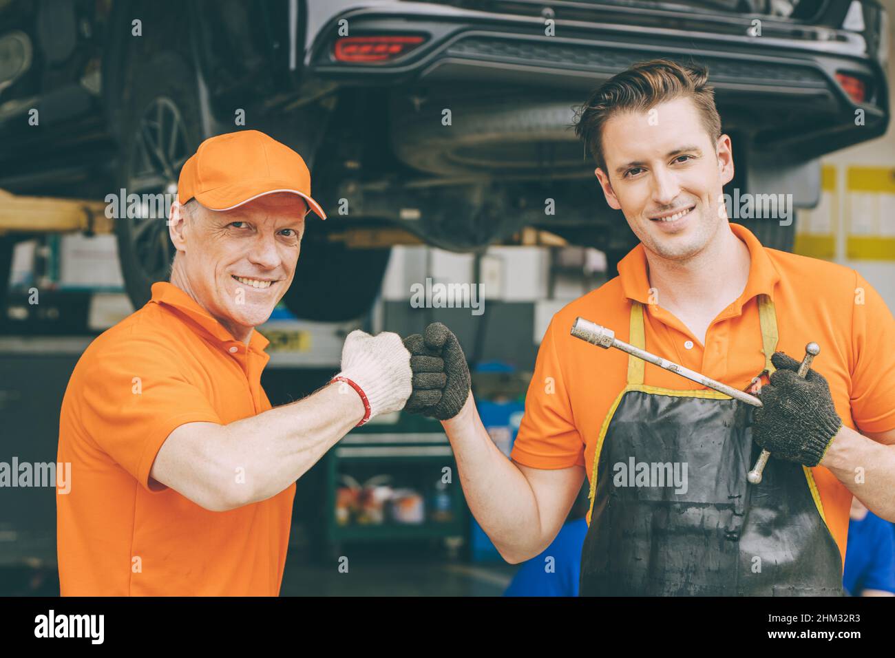 il team di assistenza per i meccanici di un'auto felice è lieto di lavorare insieme in garage Foto Stock