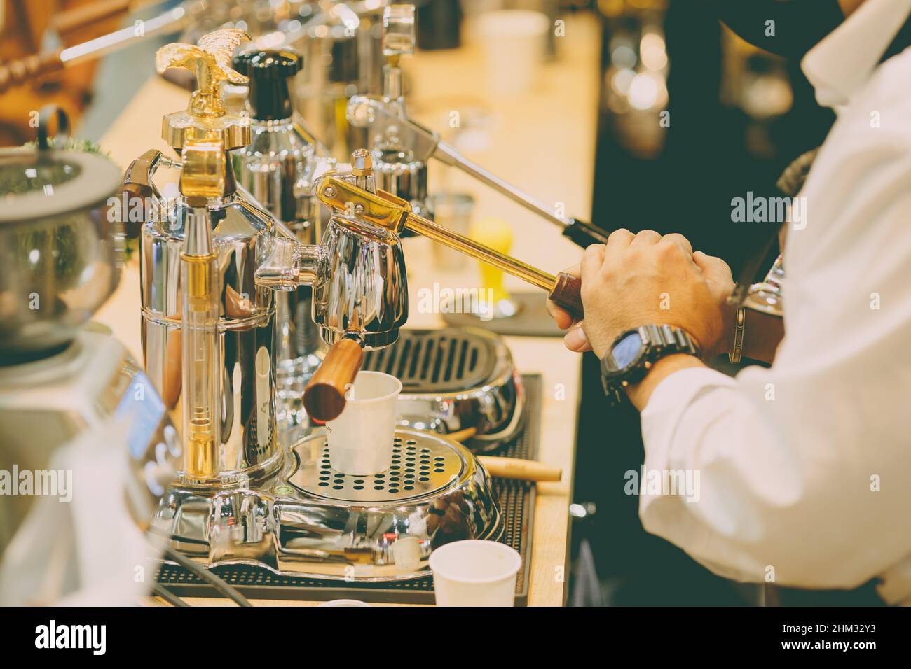 Caffè barista utilizzando la leva manuale estrattore caffè espresso macchina da caffè a mano stile di classe Foto Stock