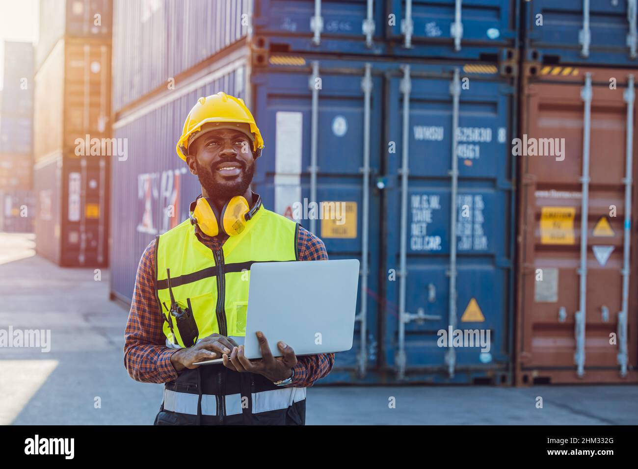 Personale nero africano che lavora nel porto logistico di spedizione merci con computer portatile. Foto Stock