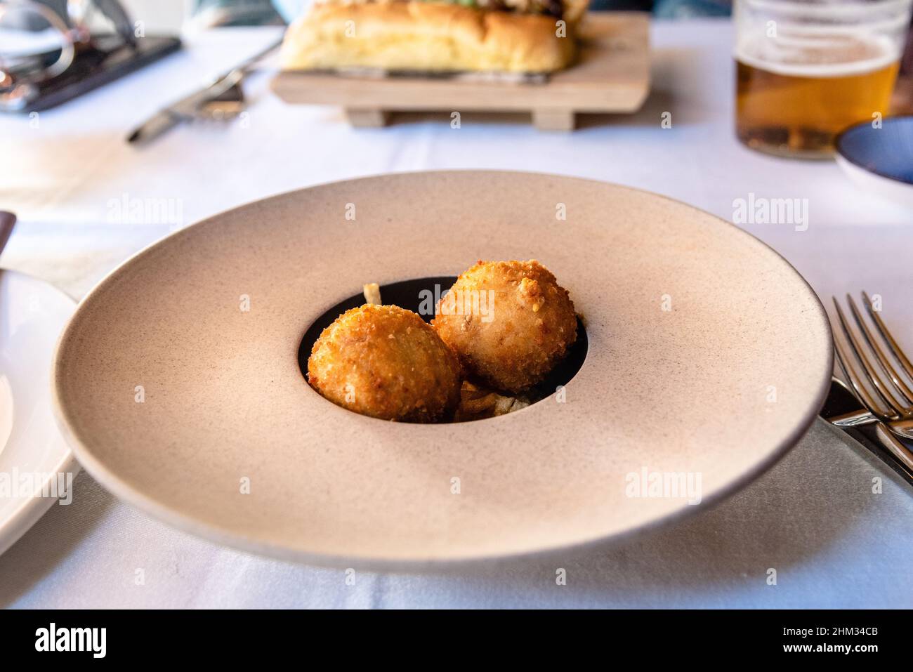 Crocchette sul piatto. Delizioso pasto di cucina fusion spagnola, splendido piatto decorato su un piatto preparato da un premiato chef professionista spagnolo. Foto Stock