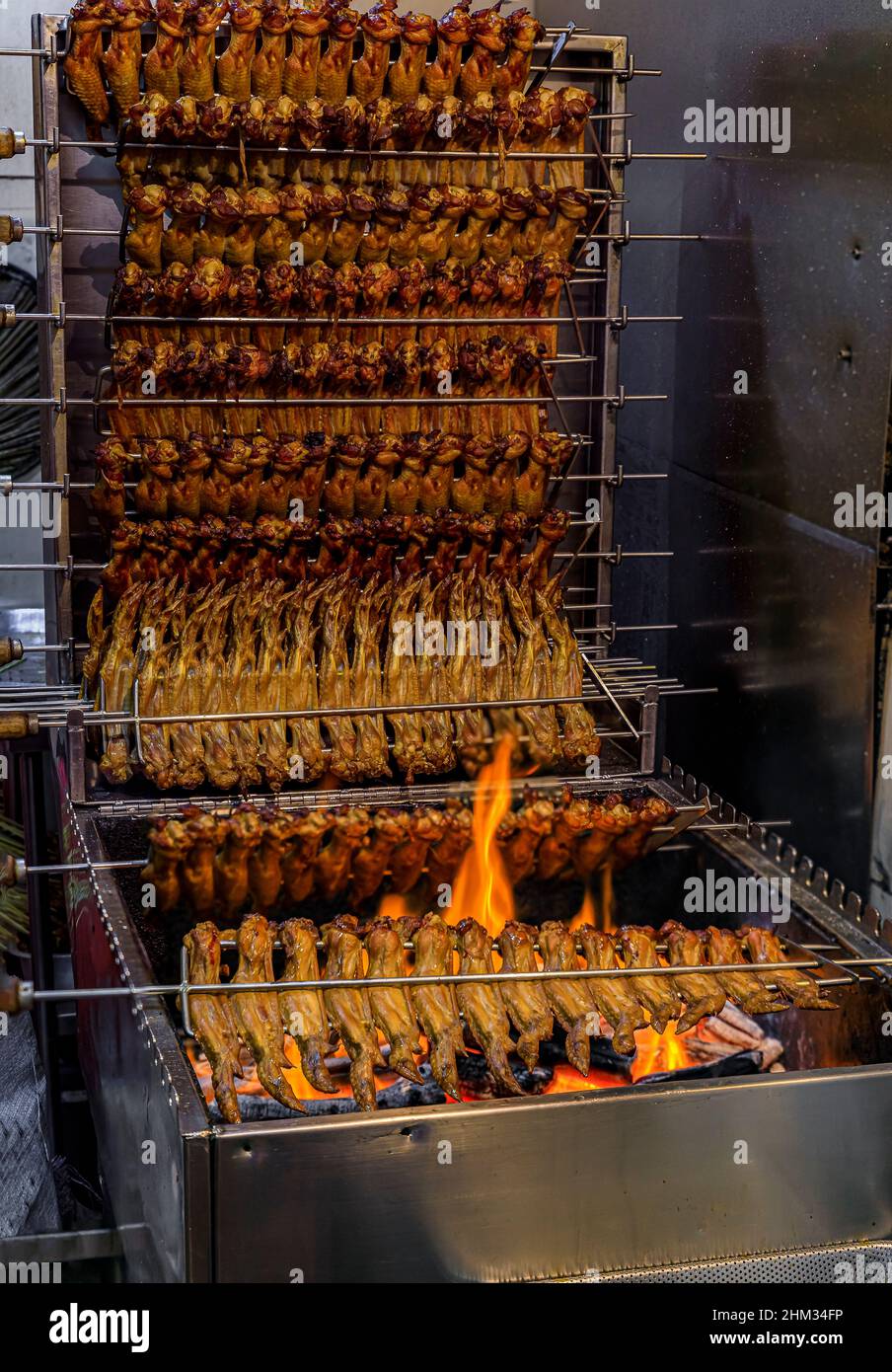 Ali di pollo fresche e grandi grigliate a fuoco aperto in una bancarella di falchi a Singapore Foto Stock