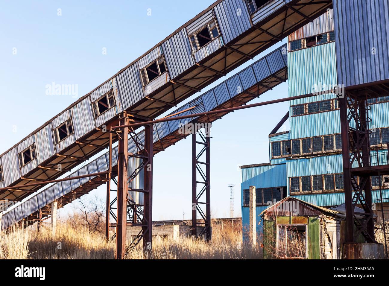 Vecchio impianto di calcestruzzo abbandonato con vasche di ferro arrugginite e strutture metalliche. La crisi, la caduta dell'economia, l'arresto della capacità di produzione ha portato al col Foto Stock