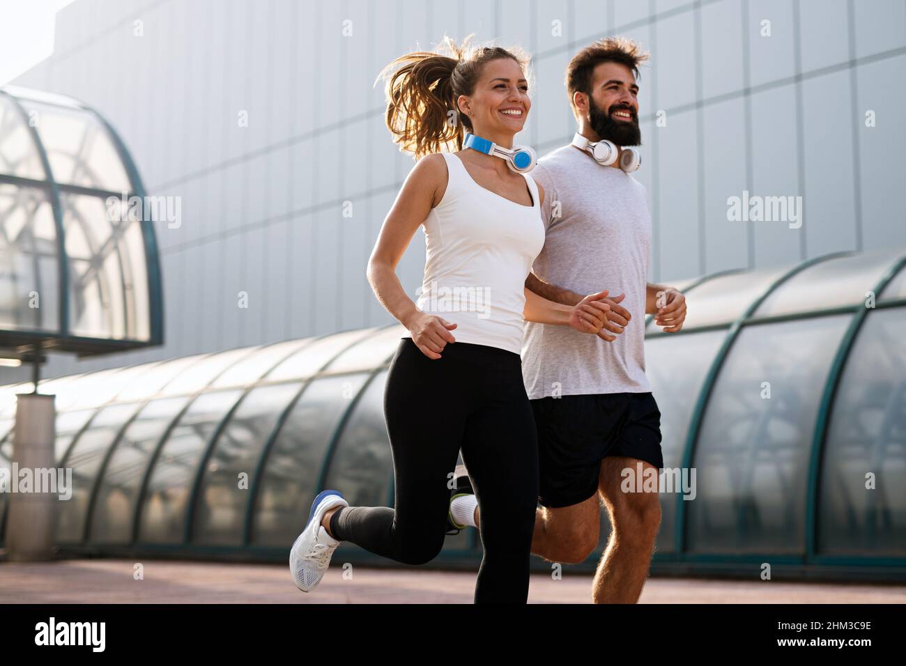 Coppia felice runner che si esercita all'esterno come parte di stile di vita sano. People sport corsa concetto Foto Stock
