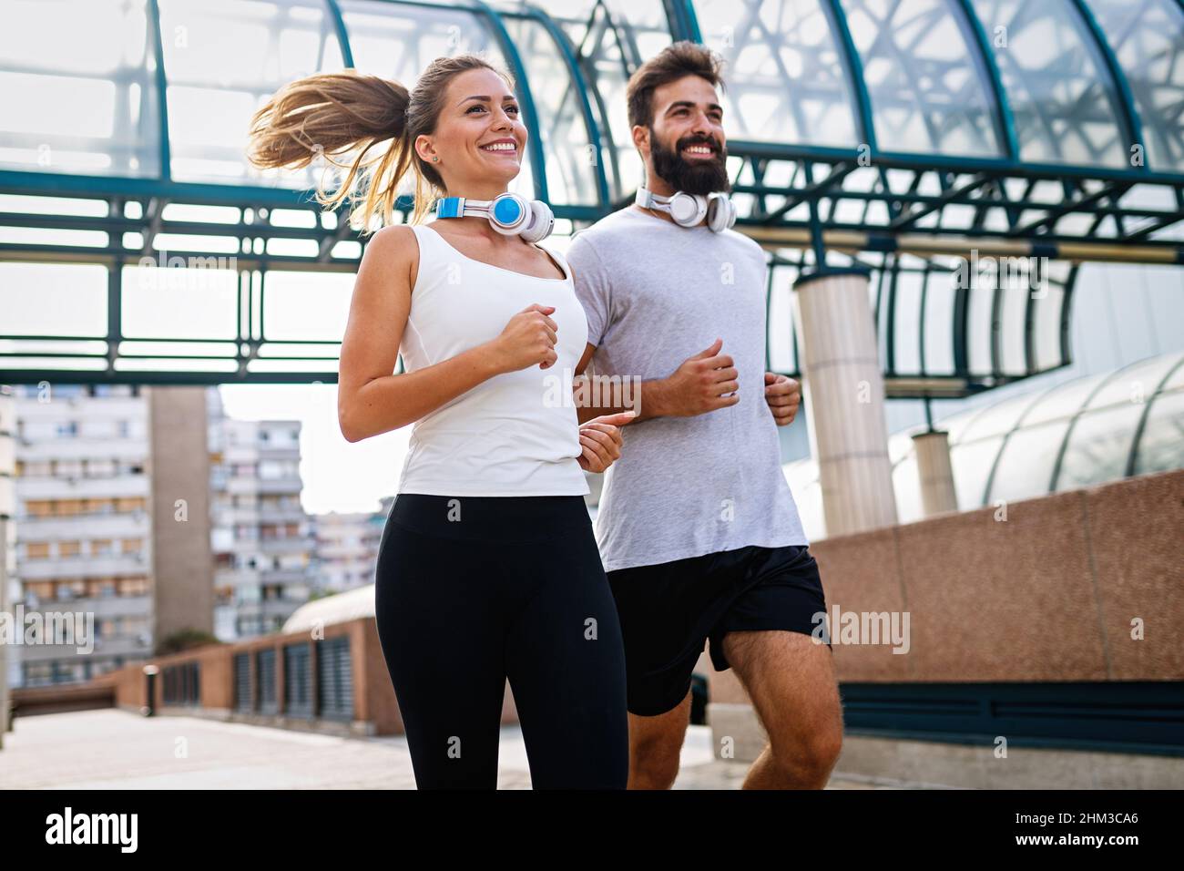 Coppia felice runner che si esercita all'esterno come parte di stile di vita sano. People sport corsa concetto Foto Stock