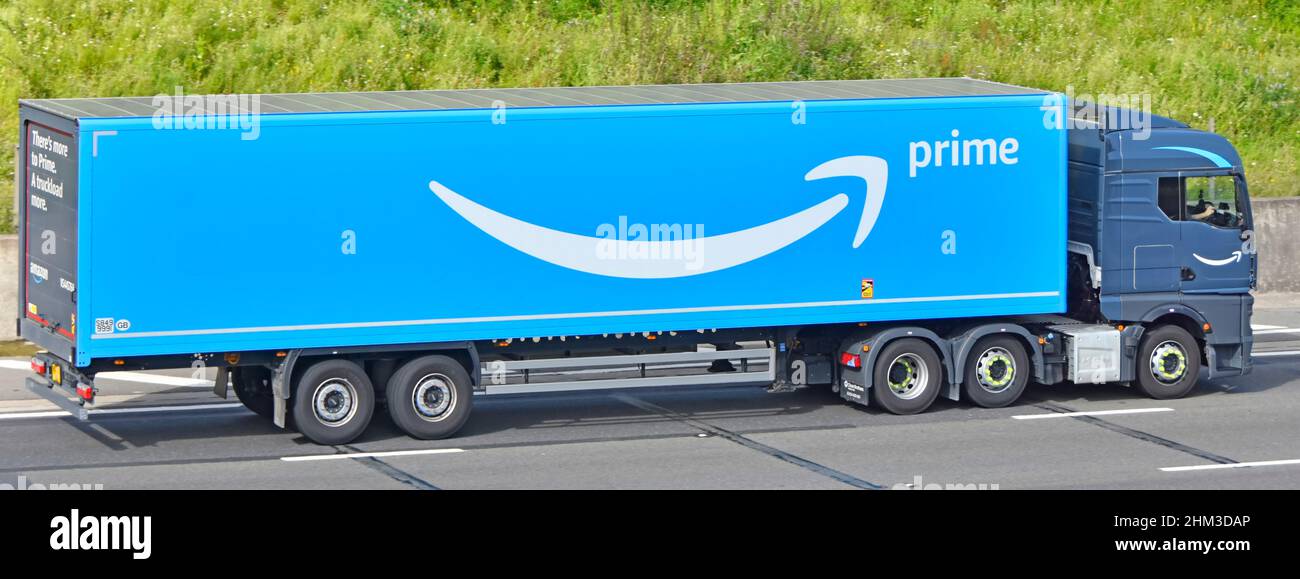 Catena di fornitura Amazon articolata blu pubblicità consegna rimorchio  conducente e logo marchio sul lato e retro vista grigio camion hgv guida su  autostrada UK Foto stock - Alamy