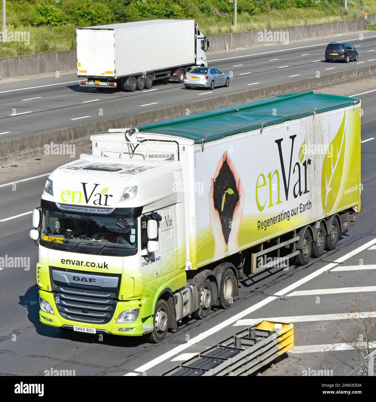EnVar rifiuti organici & biomassa business hgv camion rimorchio & conducente grafica vista frontale & aerea dall'alto guida lungo la strada autostradale del Regno Unito Foto Stock