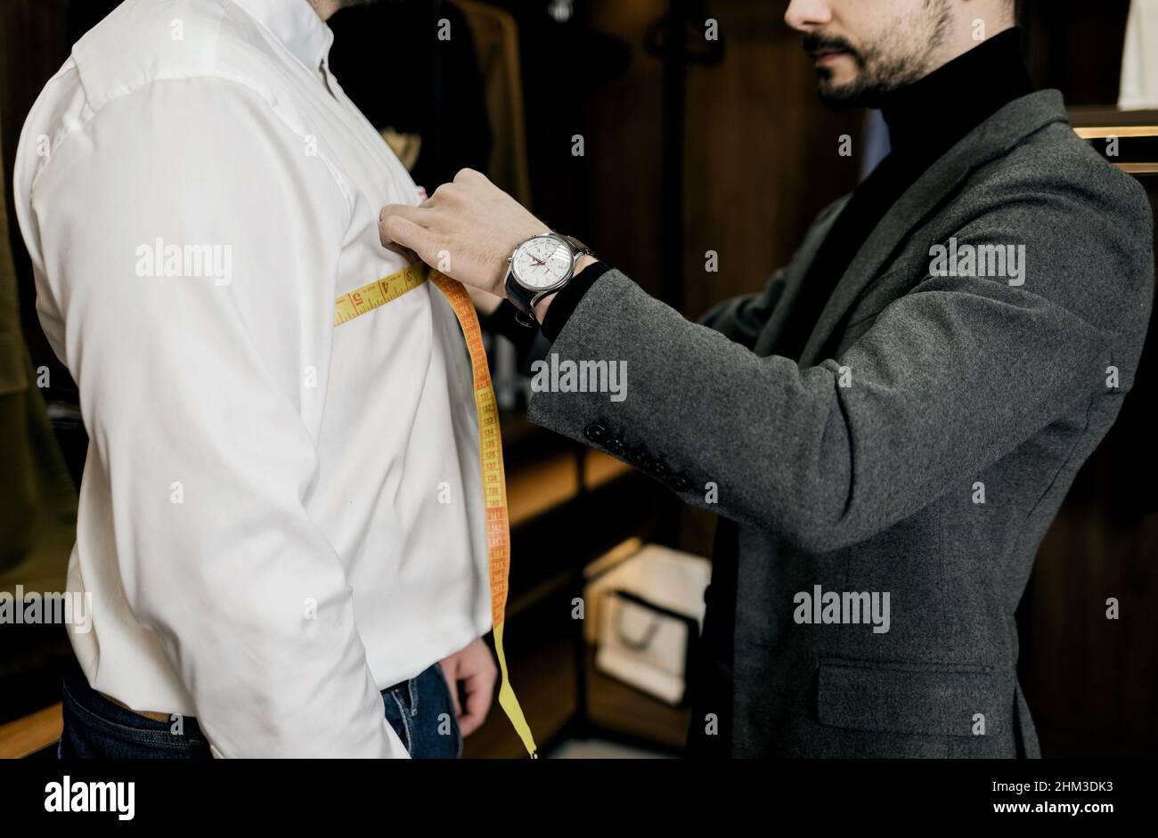 su misura in vecchio stile per misurazioni del polso da parte del cliente in un piccolo studio di atelier Foto Stock
