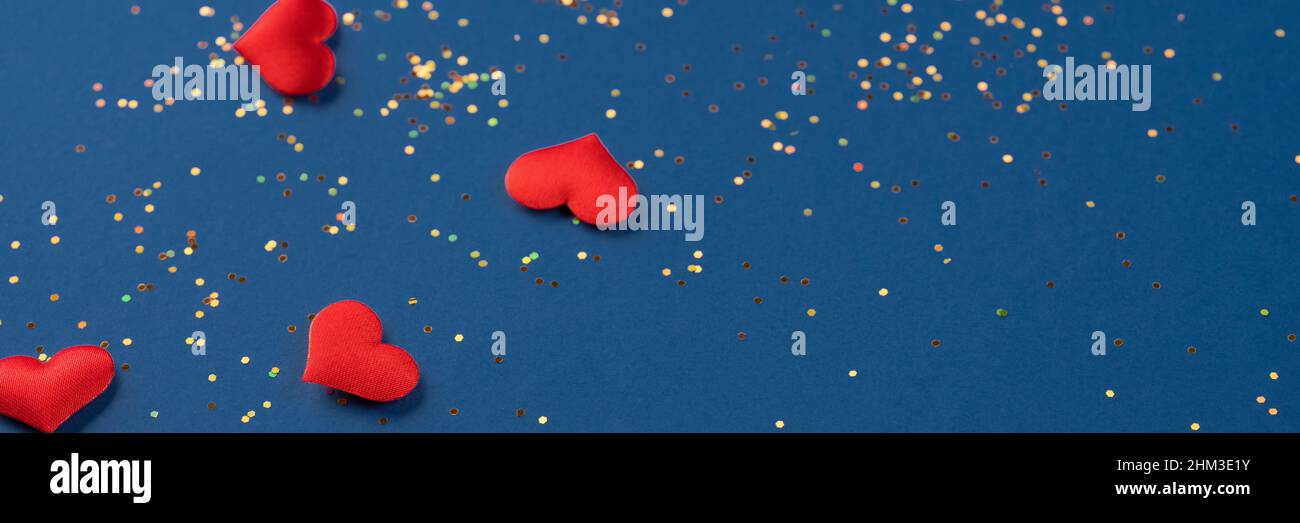 Sfondo festivo con cuori rossi e luci olografiche multicolore su sfondo blu scuro. San Valentino sfondo giorno per il vostro progetto Foto Stock