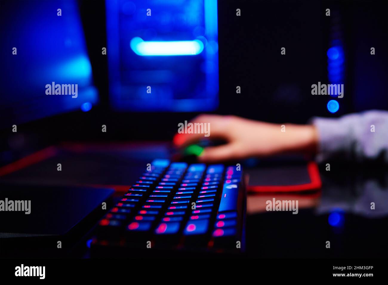 Ragazzo adolescente giocare video gioco computer in camera oscura, utilizzare tastiera meccanica rgb neon colorato, luogo di lavoro per il gioco di cybersport Foto Stock