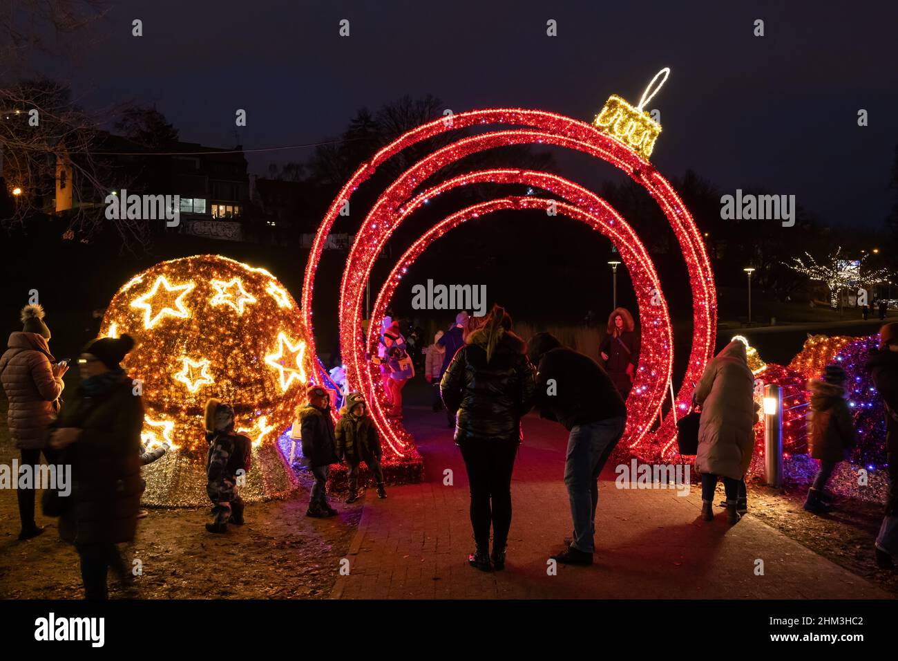 Varsavia, Polonia - 1 gennaio 2022: Le persone godono di illuminazione durante la stagione delle vacanze di notte nel parco cittadino. Foto Stock