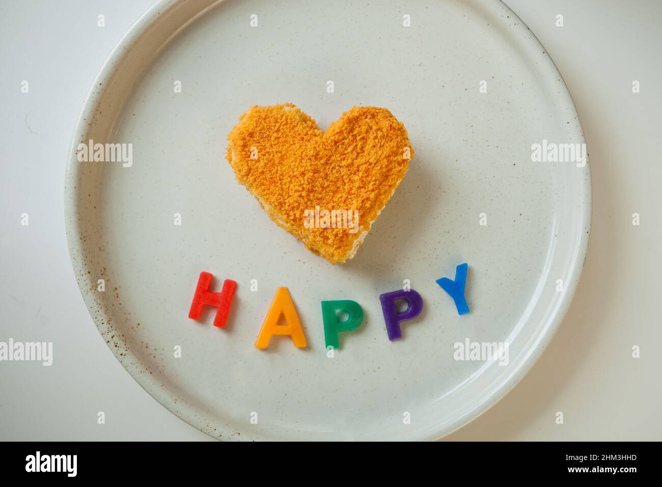 arcobaleno colori e parola felice vicino arancio cuore a forma di torta. Stile LGBT espressione della passione d'amore. Foto Stock