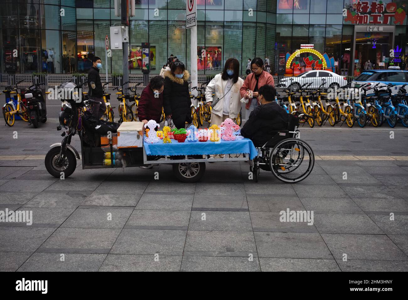 Interazione tra il venditore di sedie a rotelle e i clienti a Shenzhen, Cina Foto Stock