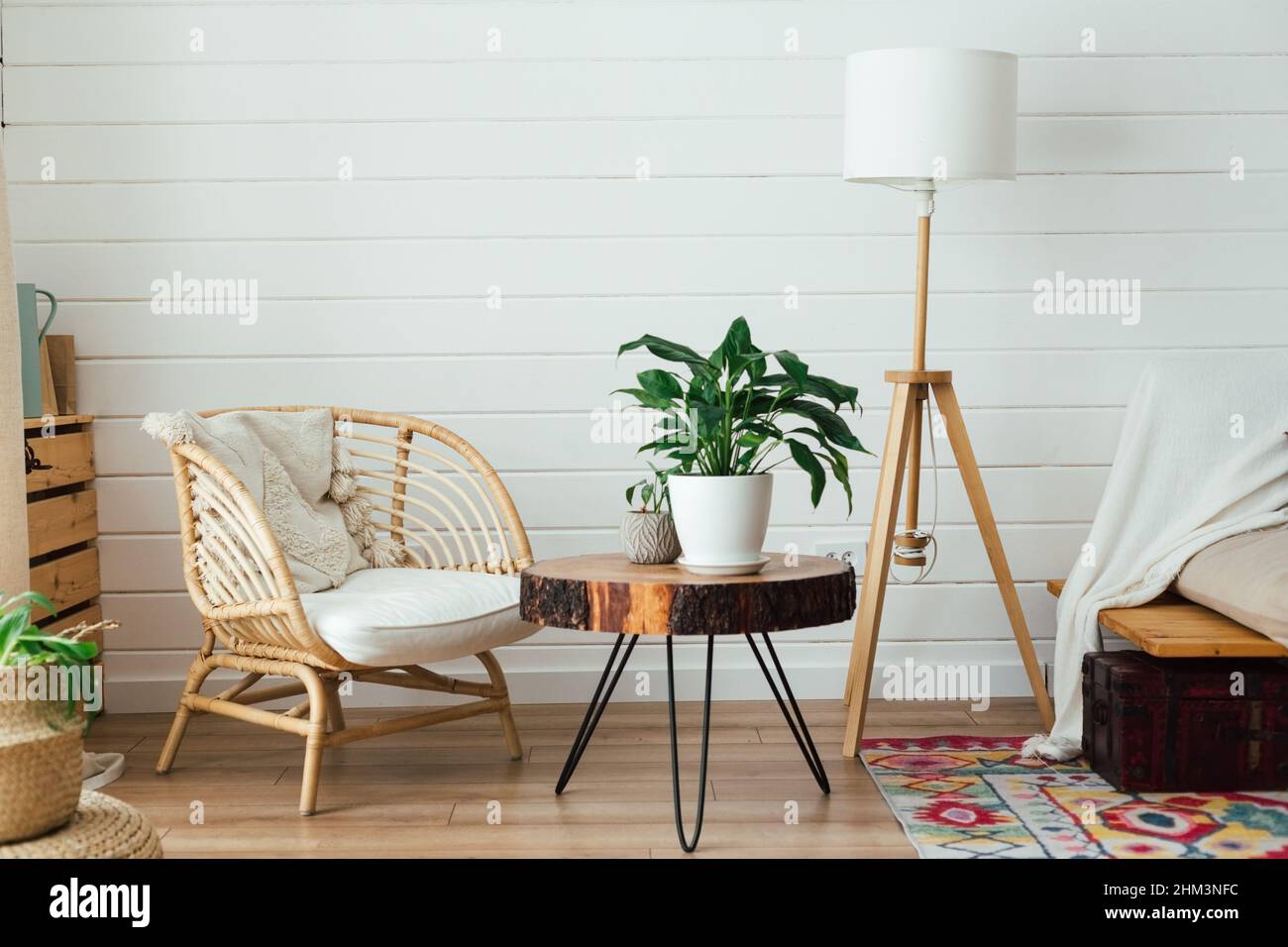Poltrona in rattan e lampada da pavimento in soggiorno interno con piante.  Interni accoglienti in stile boho. Foto reale Foto stock - Alamy