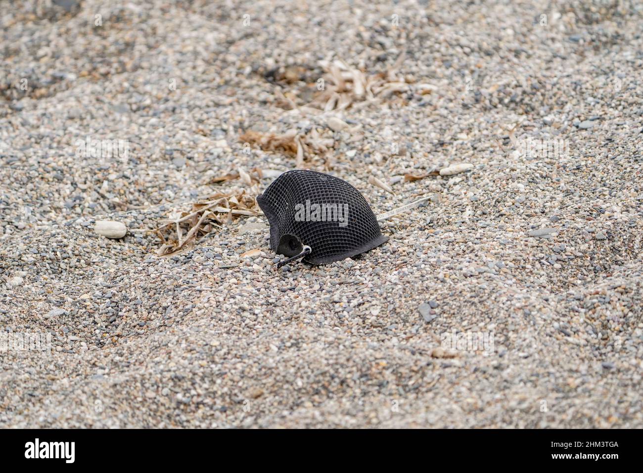 Maschera protettiva nera adagiata sulla spiaggia, Spagna. Foto Stock