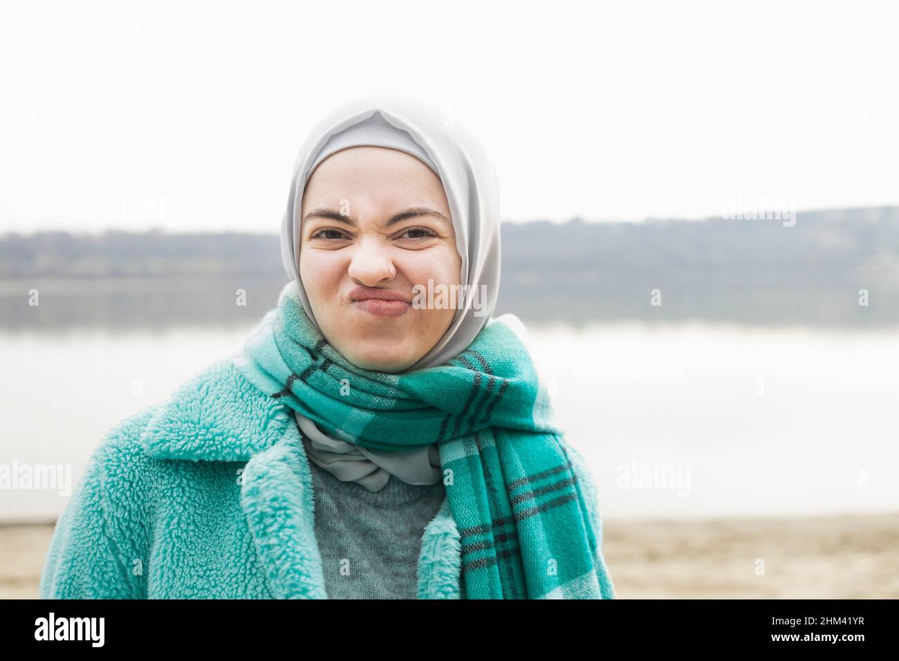 Una donna vestita di blu facendo volti Foto Stock