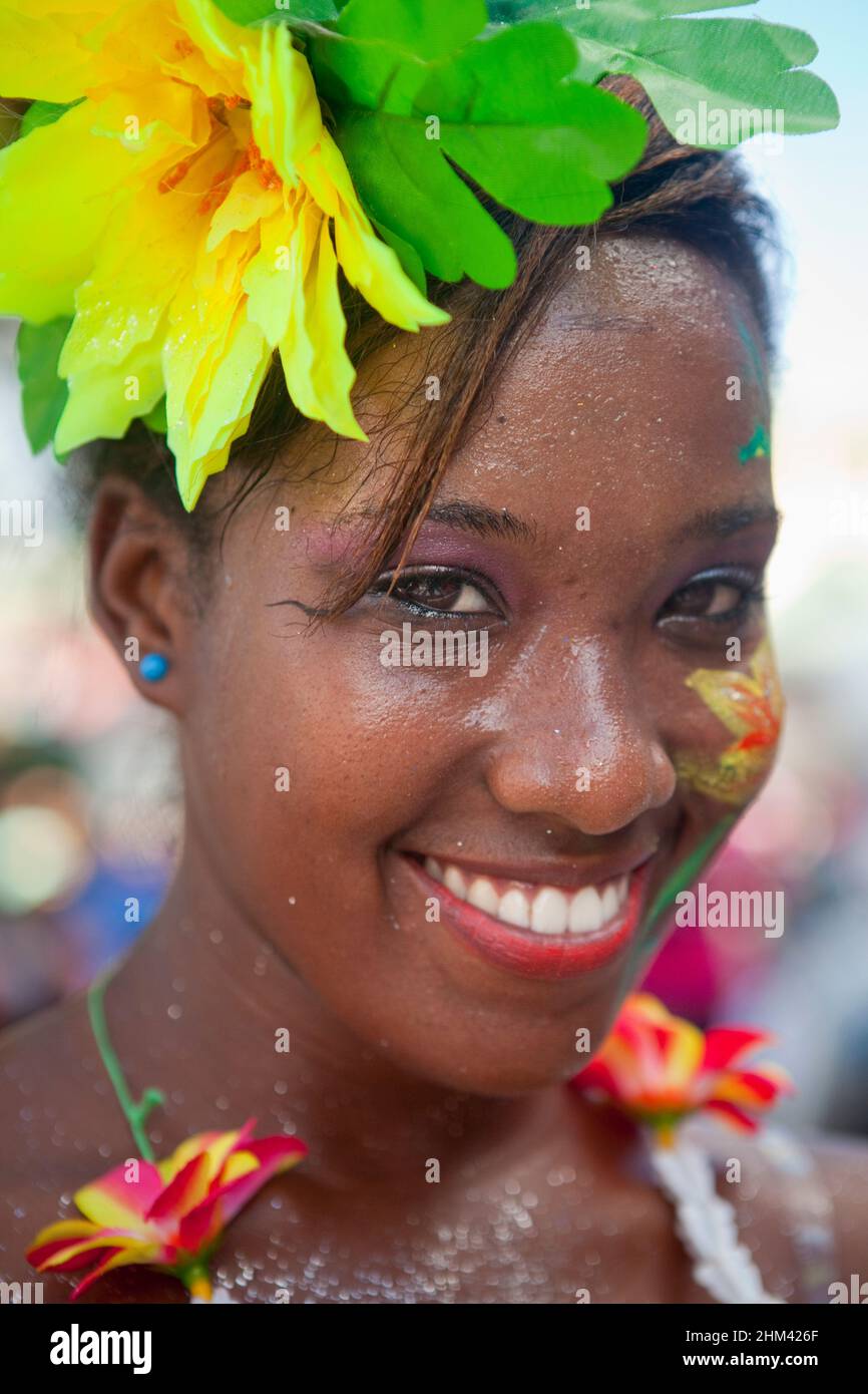 Ritratto di giovane donna sorridente e che indossa una ghirlanda di fiori mentre si esibisce per strada durante il Carnevale alle Seychelles. Foto Stock