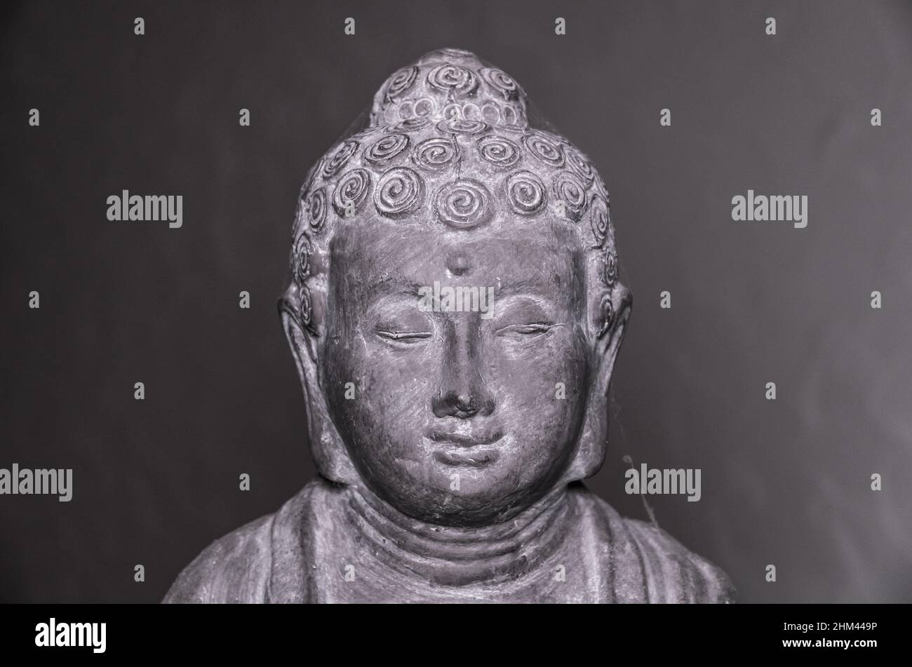 Statua del Buddha di Siddharha Gautama in pietra grigia come decorazione interna, vista ravvicinata del ritratto Foto Stock