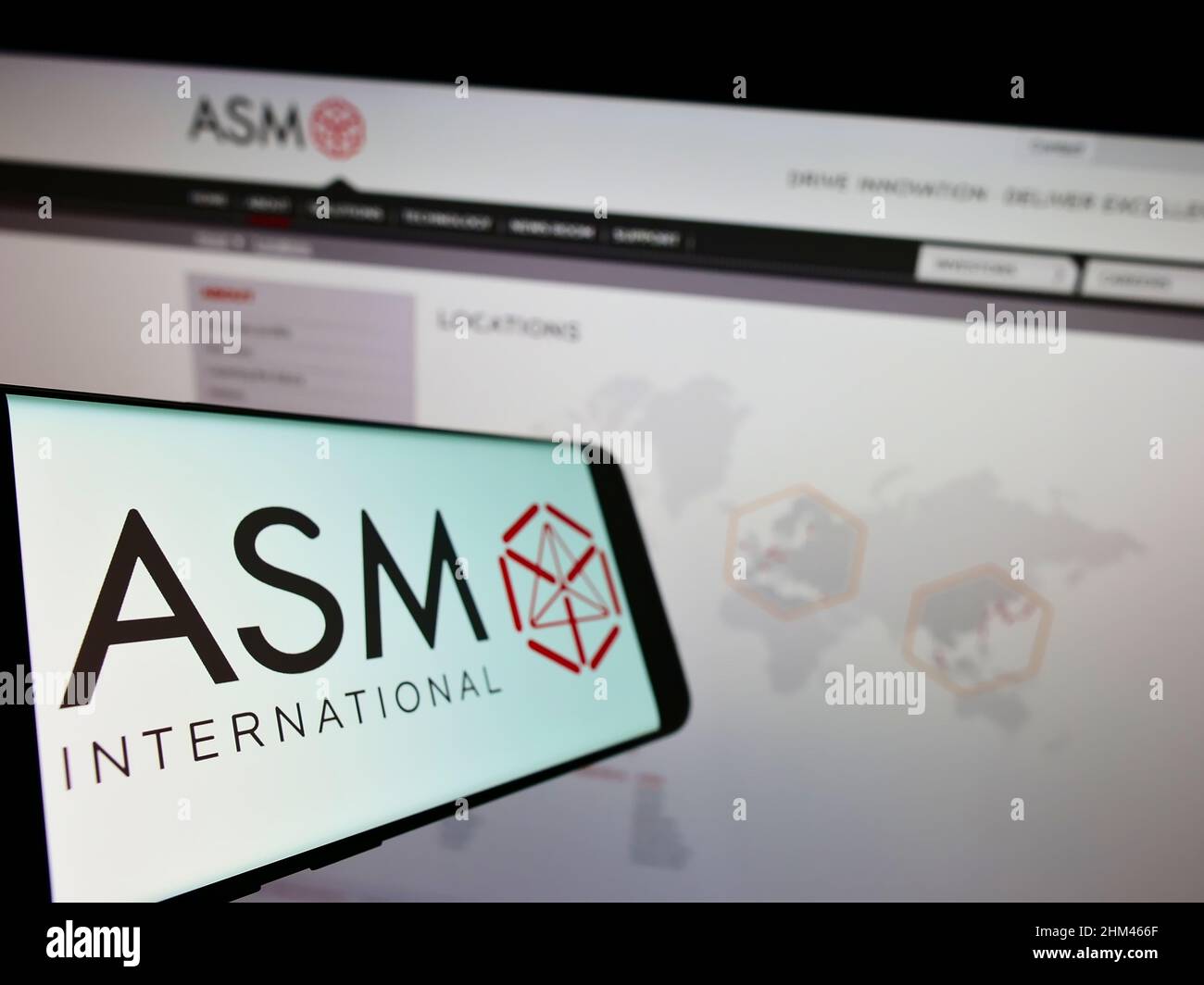 Cellulare con logo della società olandese di semiconduttori ASM International N.V. sullo schermo di fronte al sito web aziendale. Mettere a fuoco sulla sinistra del display del telefono. Foto Stock