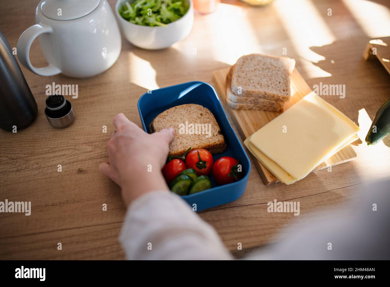 Primo piano della madre che prepara uno spuntino al pranzo al sacco in cucina a casa. Foto Stock