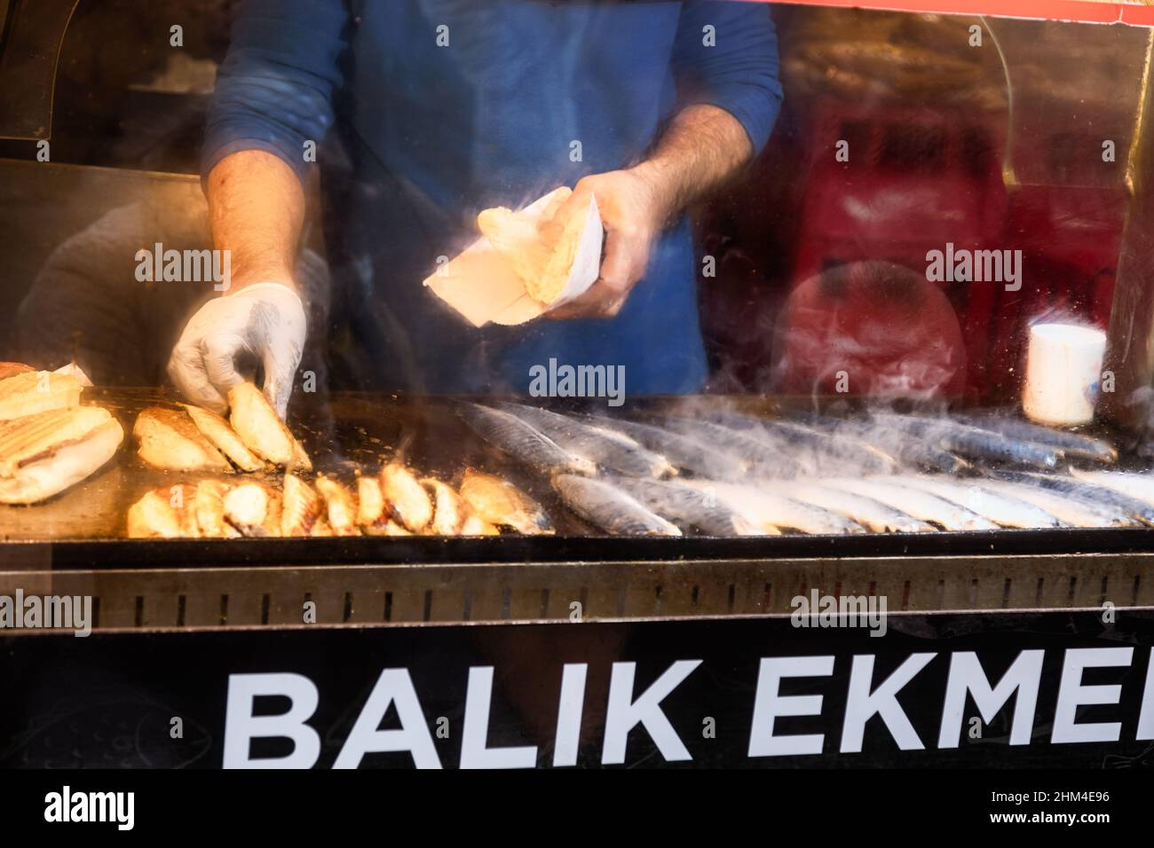 Chef di produzione tradizionale turco Street food Balik Ekmek arrosto filetto di sgombro a Istanbul, Turchia Foto Stock
