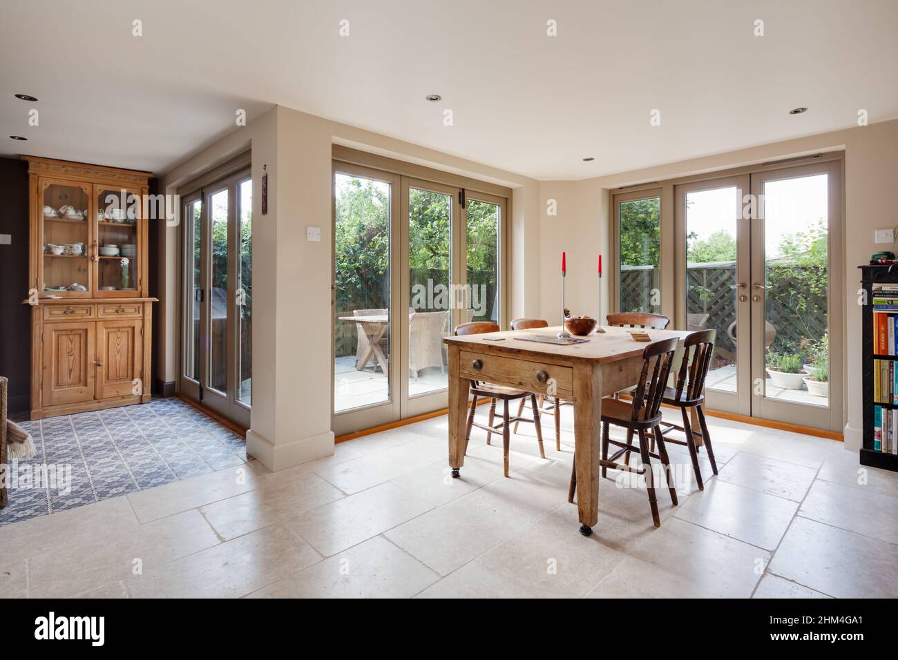 Zafferano Walden, Essex - Agosto 31 2017: Sala da pranzo in stile tradizionale con tavolo in stile casale posizionato di fronte a porte bifold che si aprono a outsid Foto Stock