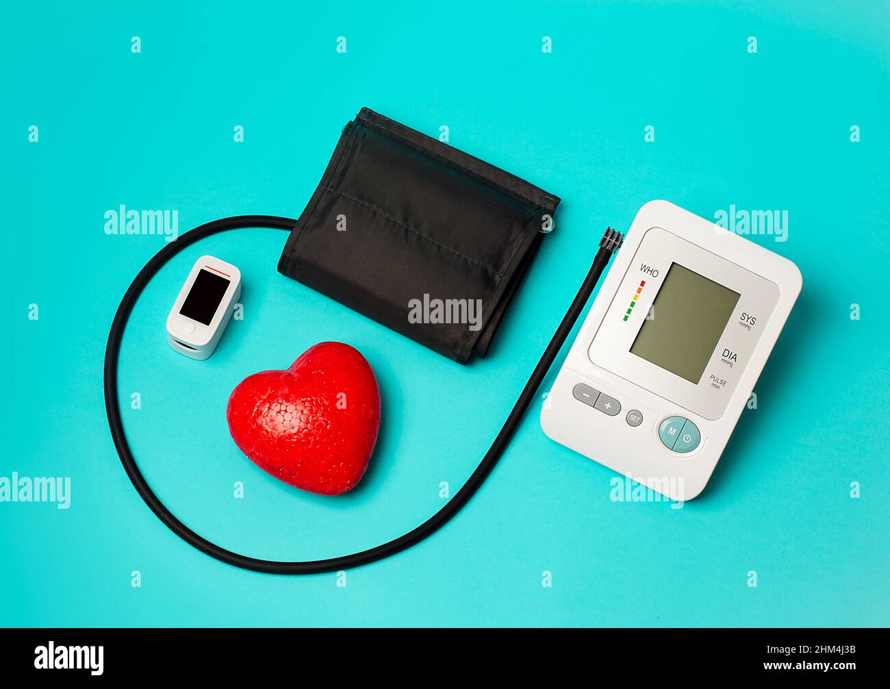 Su base medica, un tonometro automatico per la misurazione della pressione, un pulsossimetro, un cuore rosso. Misurazione del livello di ossigeno nel sangue. Foto Stock