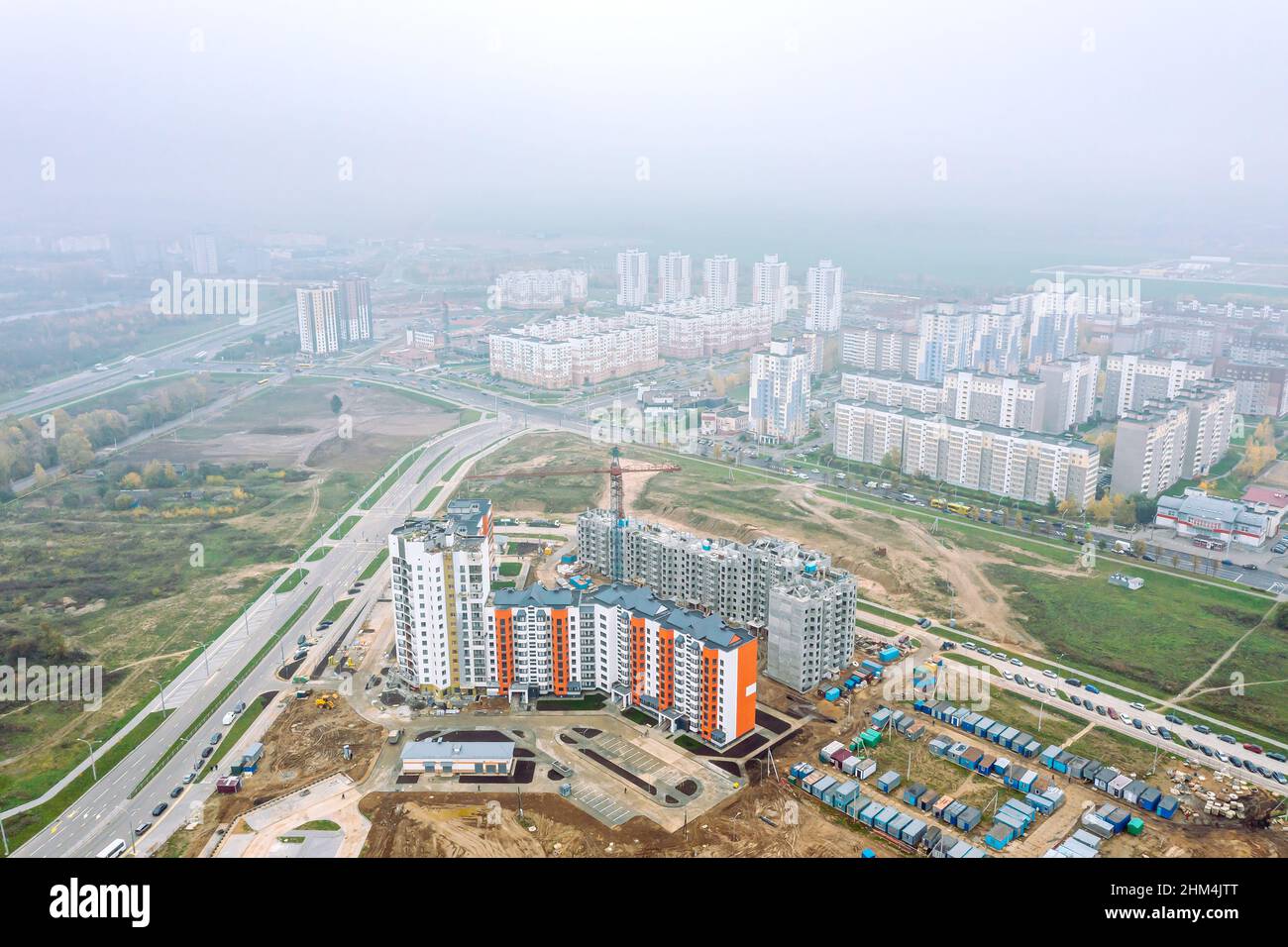 sviluppo di nuova zona residenziale. vista aerea panoramica del cantiere urbano in giornata di nebbia. Foto Stock