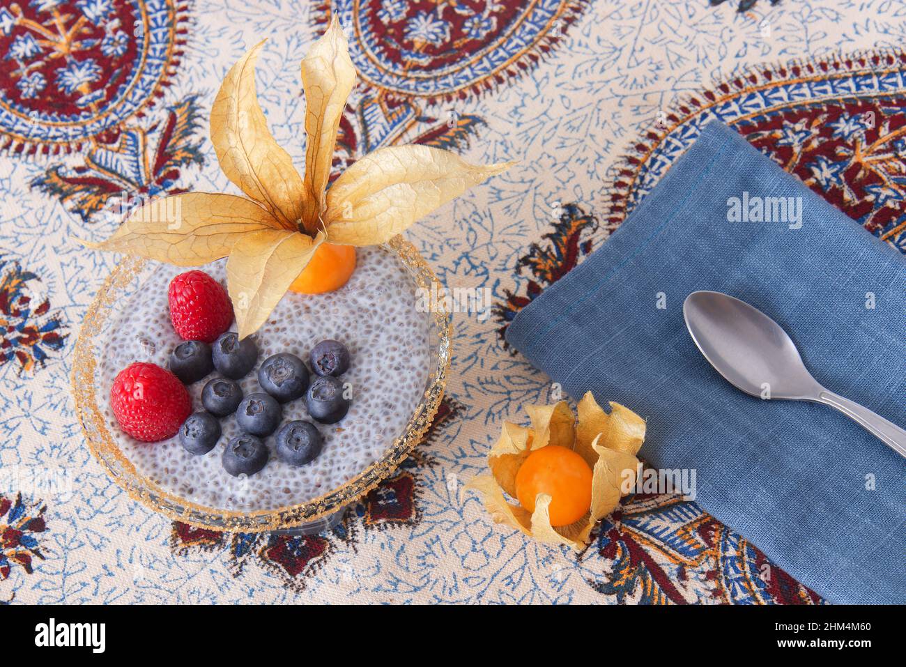 Primo piano del dessert chia budino con bacche estive, lamponi, mirtilli, banane e physalis. Piatto, vista dall'alto, niente persone. Foto Stock