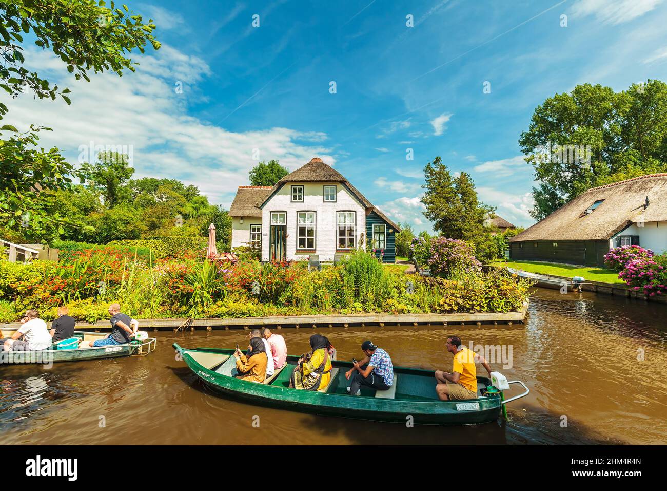 GIETHOORN, PAESI BASSI - 26 LUGLIO 2016: I turisti si godono una crociera sul canale con piccole barche nel famoso villaggio olandese di Giethoorn Foto Stock