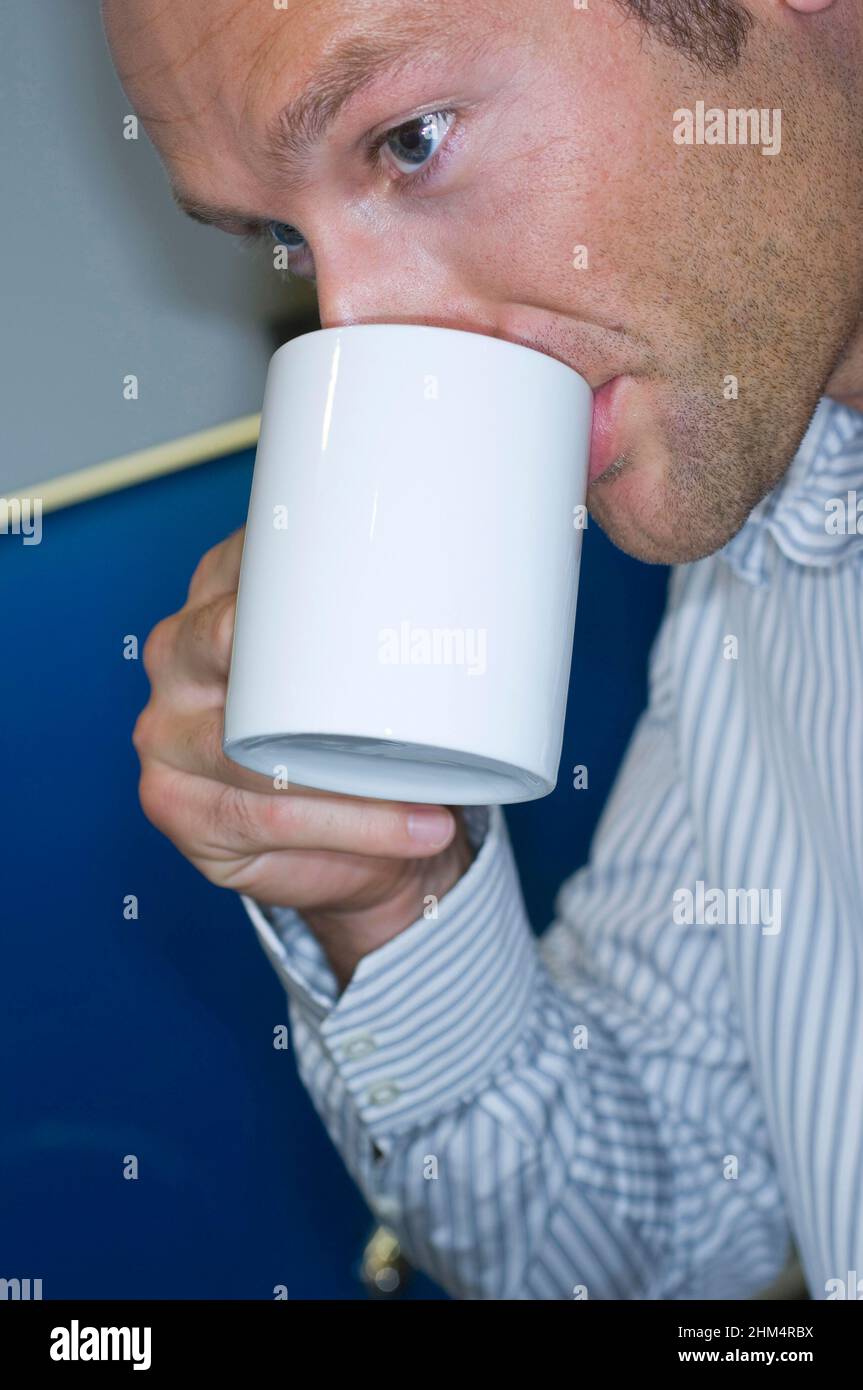 Primo piano di Un uomo d'affari che beve Una tazza di caffè, Credit:Photoshot Creative / Stuart Cox / Avalon Foto Stock