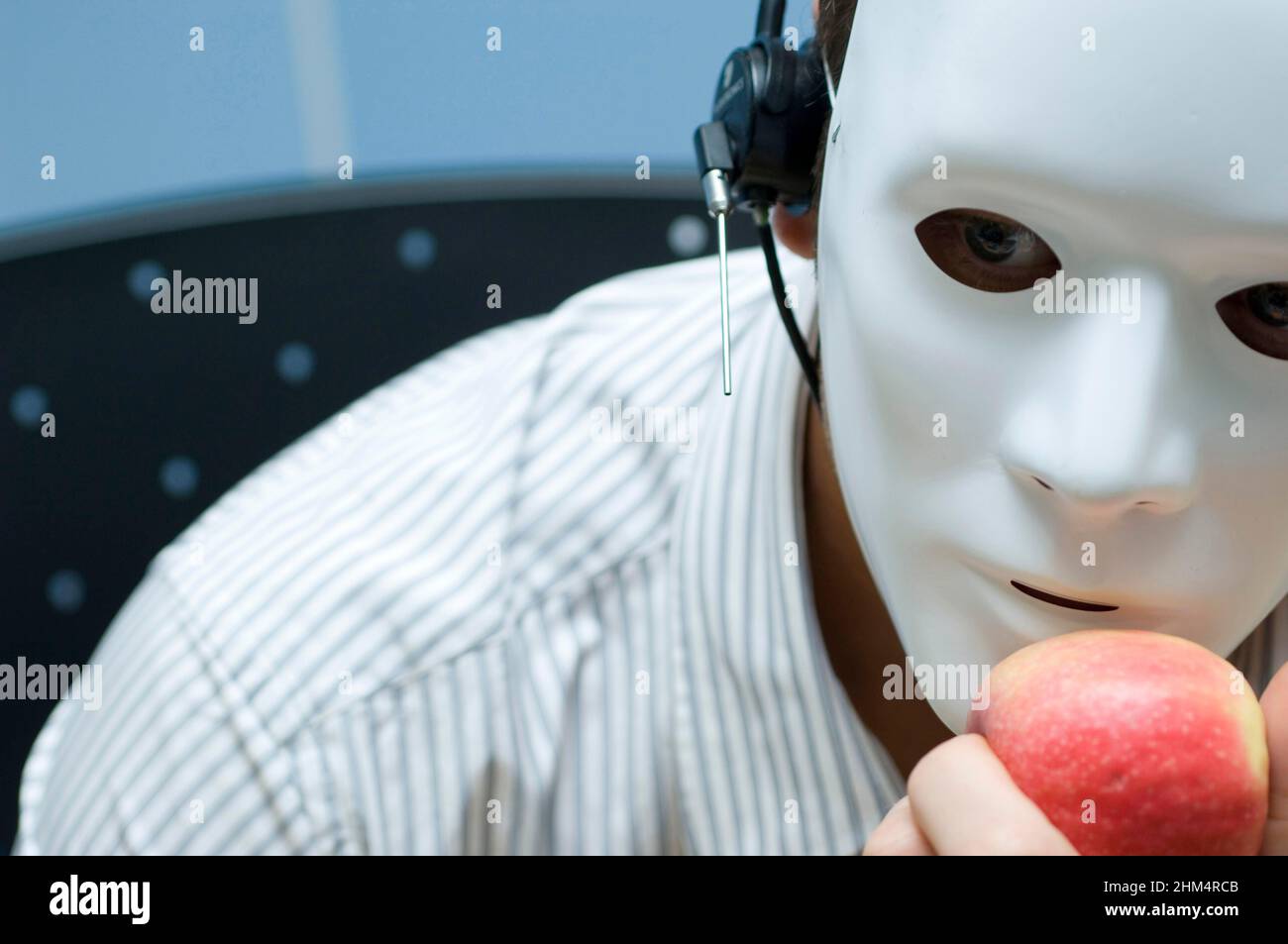 Primo piano di una persona che indossa una maschera e tiene una Apple, Credit:Photoshot Creative / Stuart Cox / Avalon Foto Stock