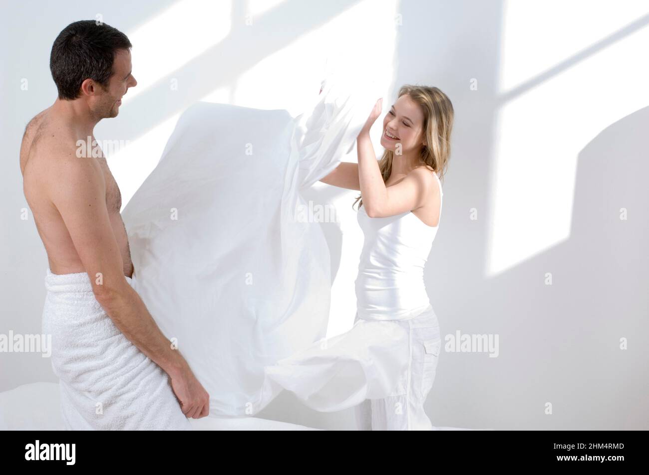 Profilo laterale di una giovane coppia giocando con Un foglio del letto, accreditamento:Photoshot Creative / Stuart Cox / Avalon Foto Stock