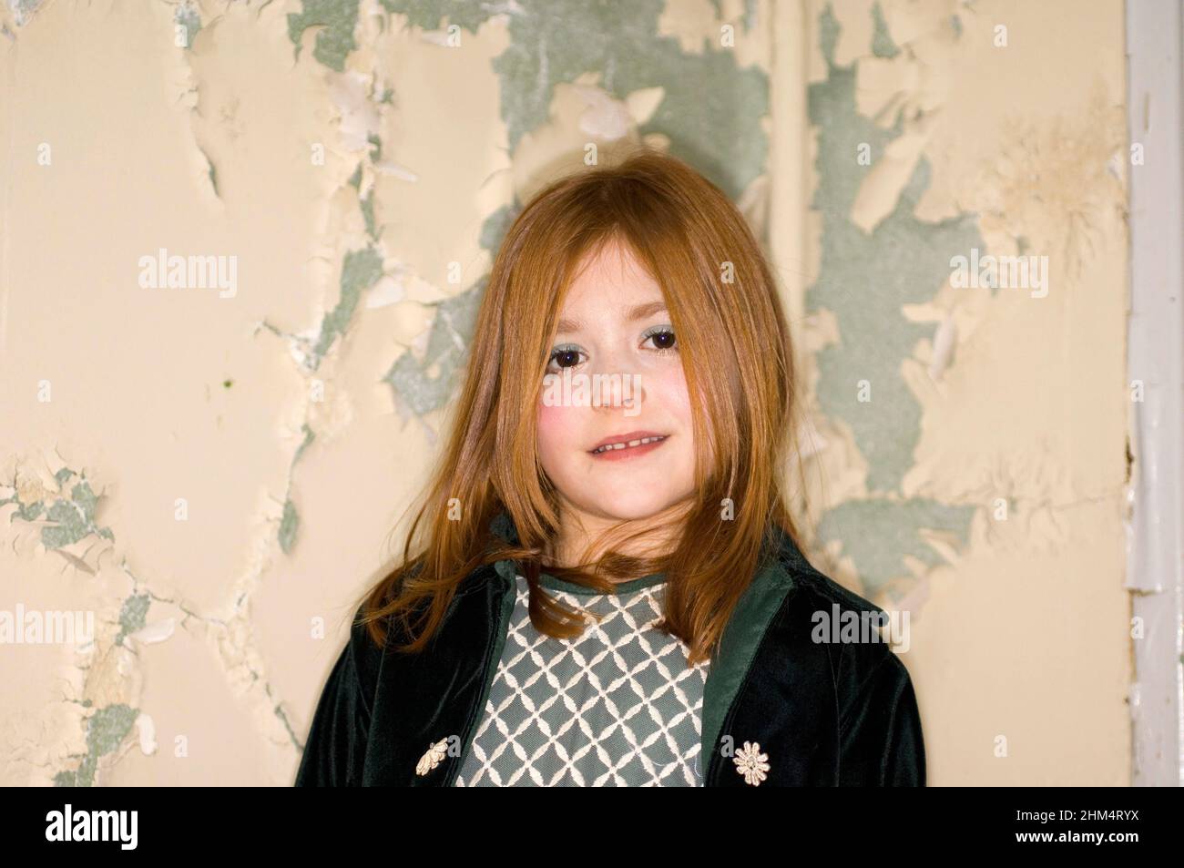 Colpo di testa di piccola ragazza felice contro il muro distressed., accreditamento:fotografia creativa / Cox di Stuart / Avalon Foto Stock