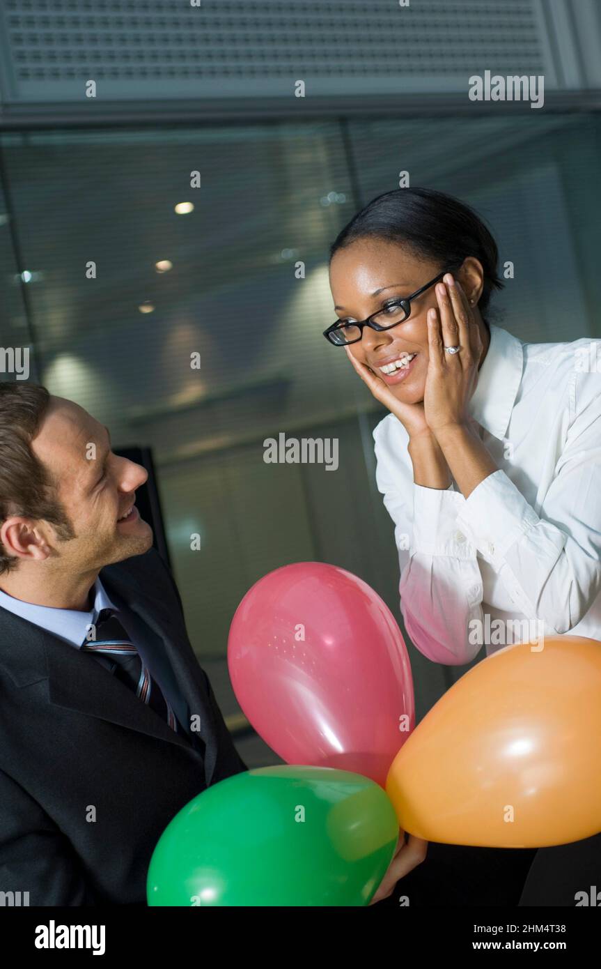 Donna d'affari che guarda un uomo d'affari e sorridente, Credit:Photoshot Creative / Stuart Cox / Avalon Foto Stock