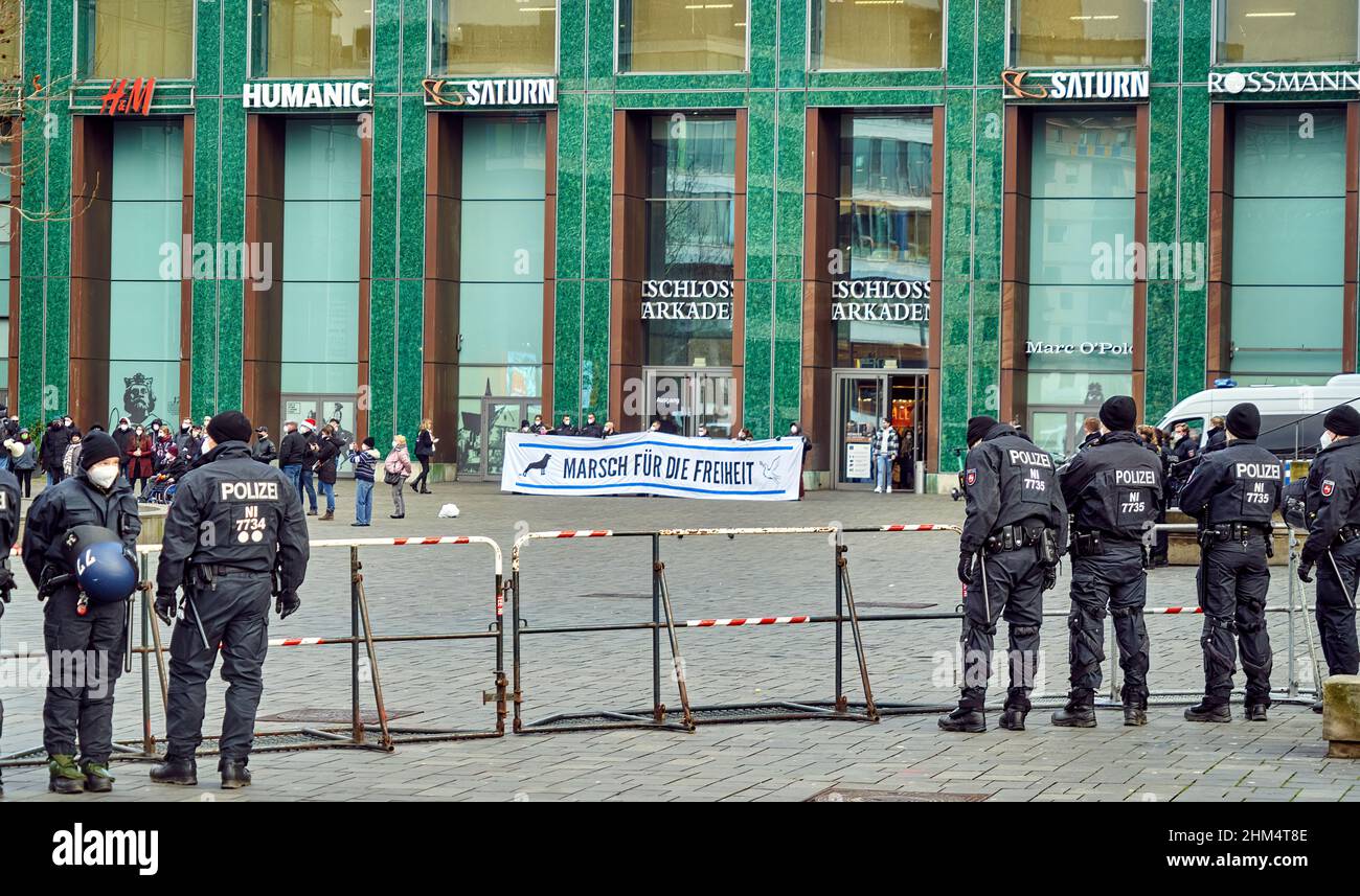 Braunschweig, Germania, 8 gennaio 2022: La polizia ha barricato di fronte ai manifestanti di un partito di destra che tiene un manifesto che chiede la libertà di fronte a un Foto Stock