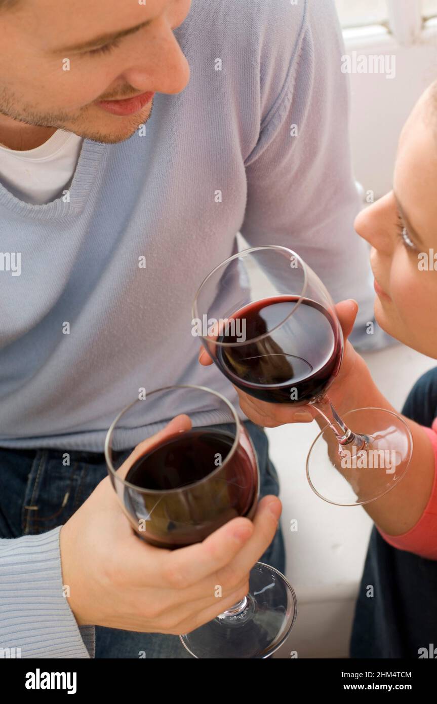 Primo piano di Una giovane coppia che tiene bicchieri di vino e si guarda l'un l'altro, Credit:Photoshot Creative / Stuart Cox / Avalon Foto Stock