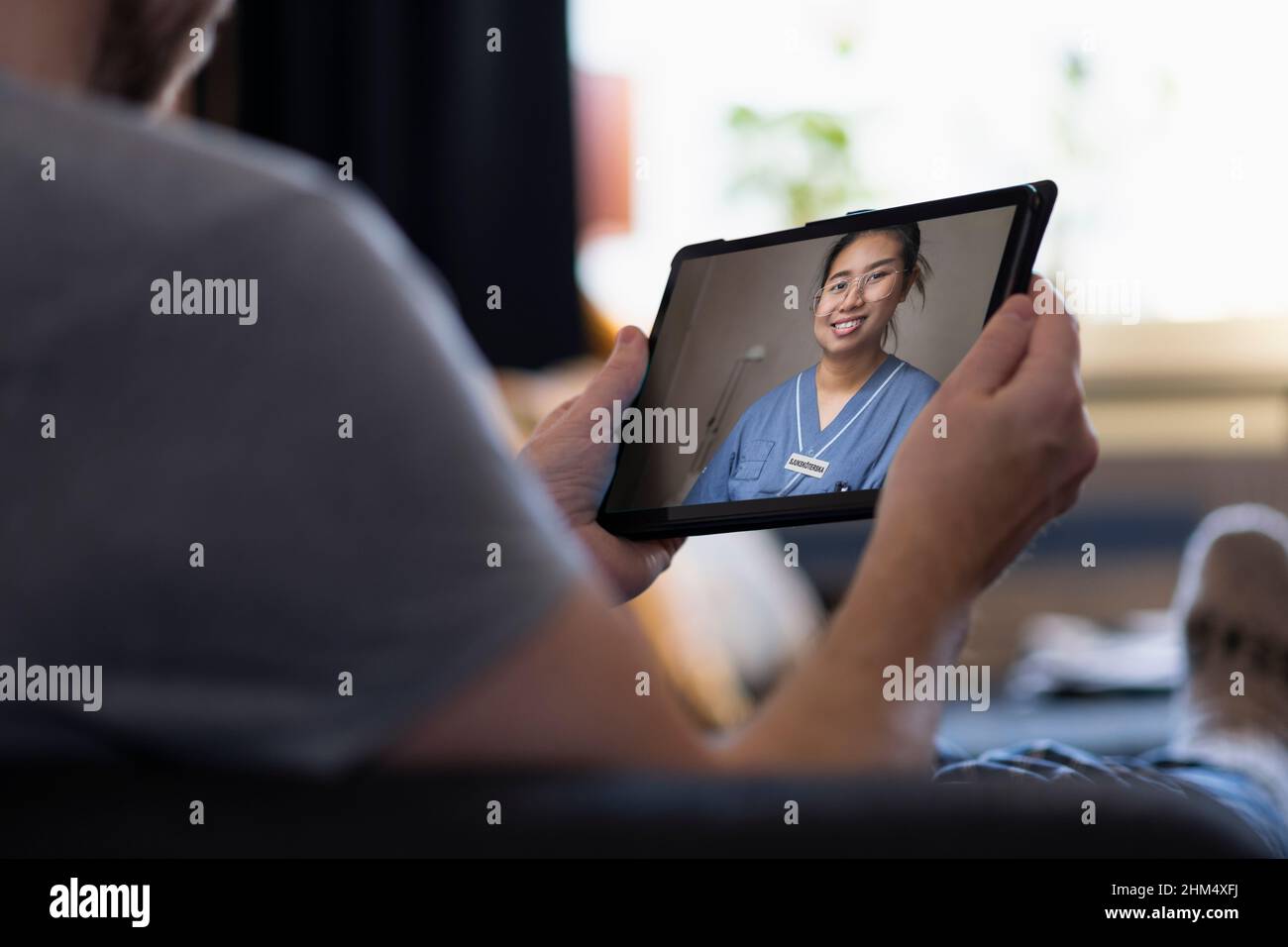 Uomo che ha una consulenza medico online su tablet digitale Foto Stock