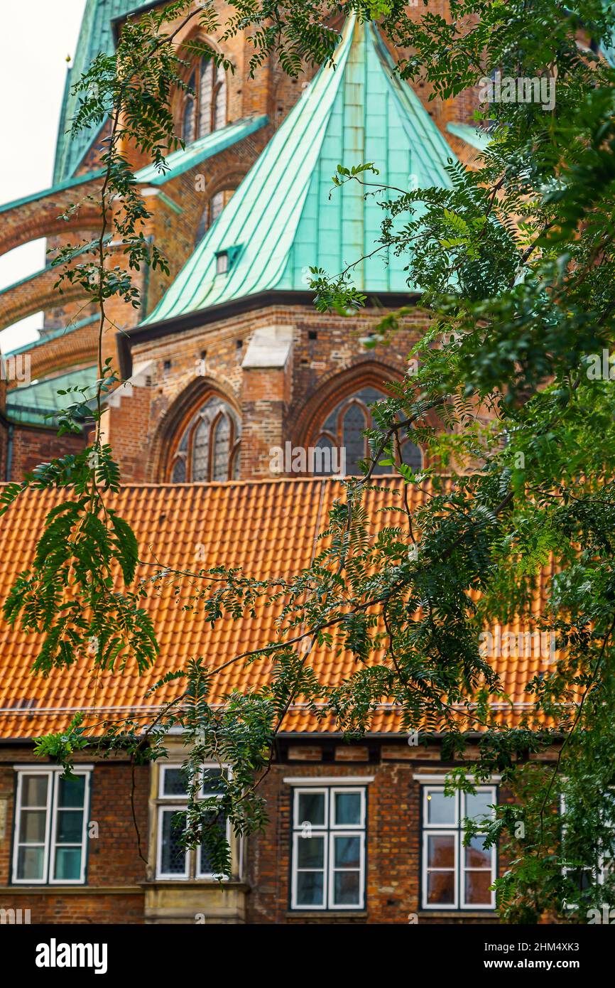 Blick auf das Kanzleigebäude und die Marienkirche im Herzen der Lübecker Altstadt - eingerahmt von Laubbäumen Foto Stock