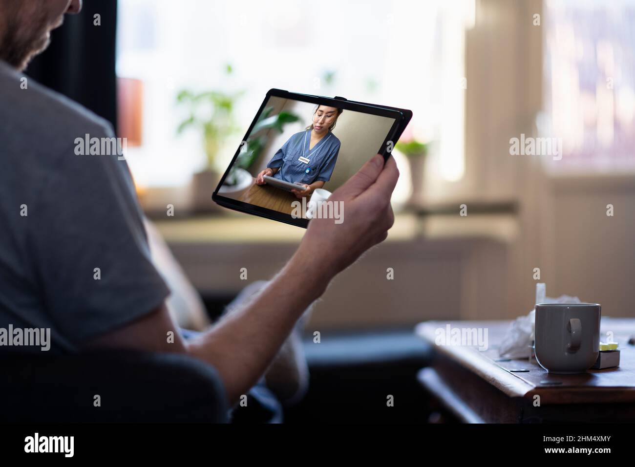 Uomo che ha una consulenza medico online su tablet digitale Foto Stock