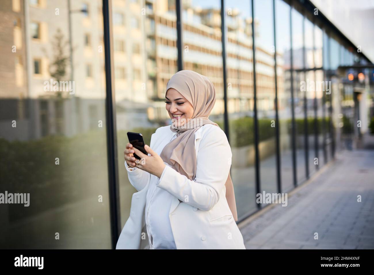 Donna sorridente con telefono cellulare Foto Stock