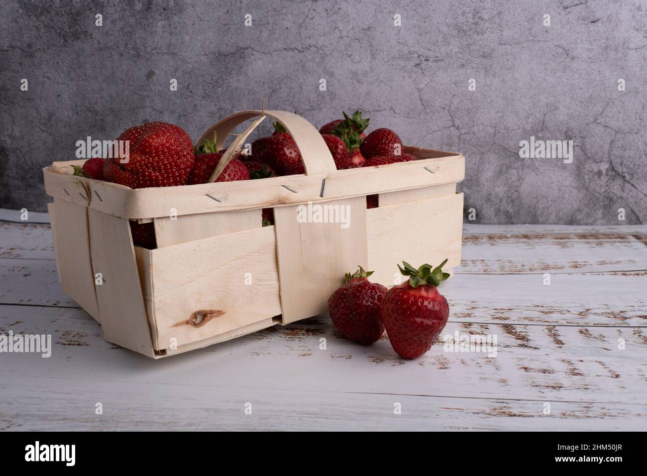 fragola fresca in un piccolo cestino di legno. Fotografato dal lato Foto Stock