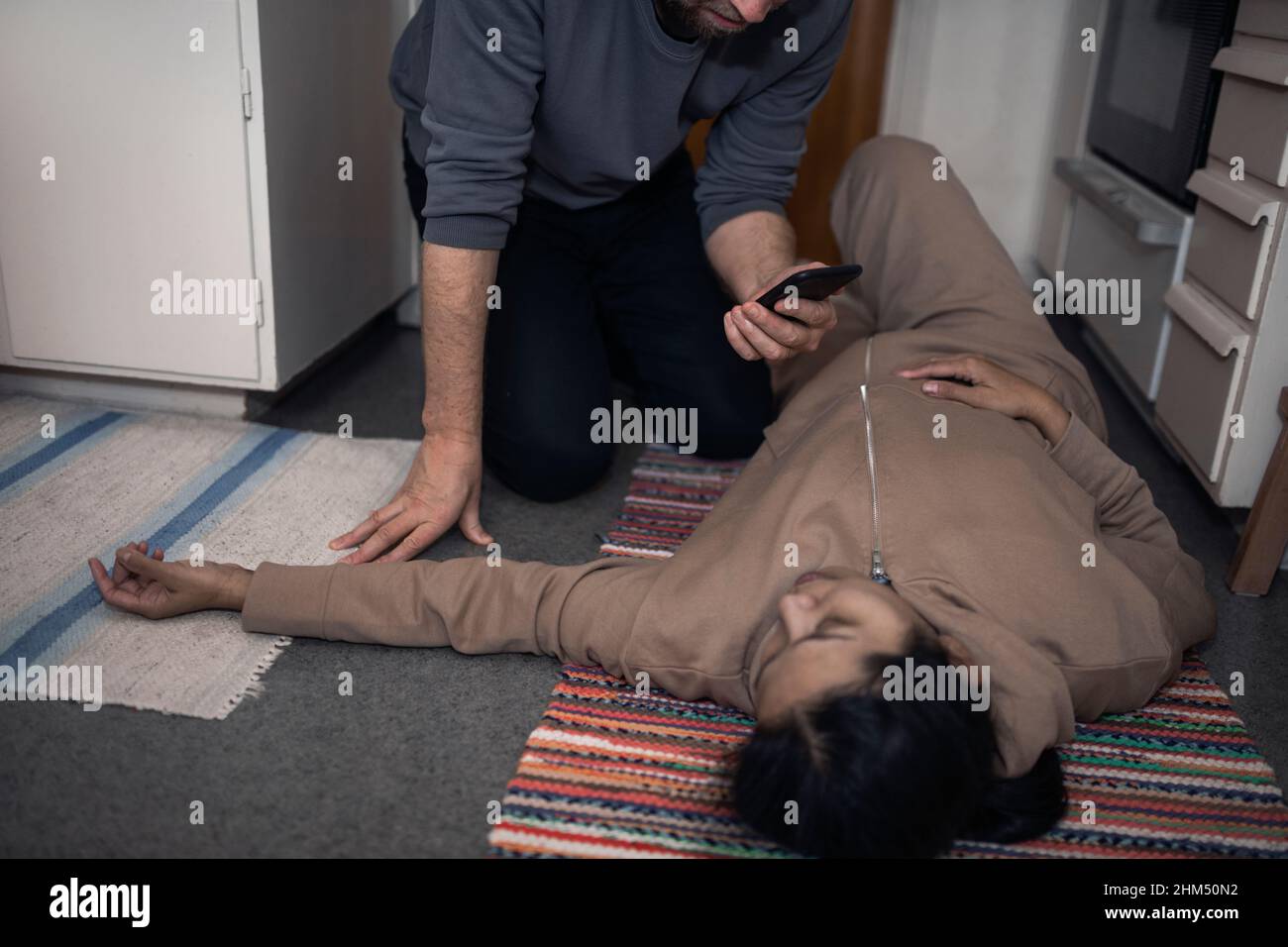 Uomo che chiede l'ambulanza per la donna inconscia in shock medico Foto Stock