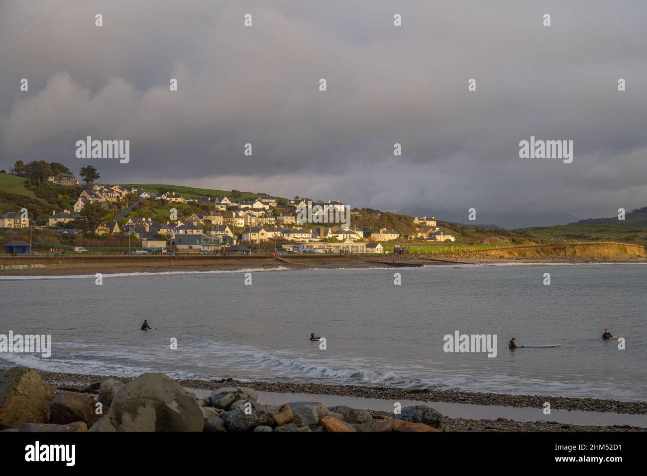 Guardando verso il lungomare di Criccieth dal frangiflutti con il sole invernale nel tardo pomeriggio che colpisce le case della città Foto Stock