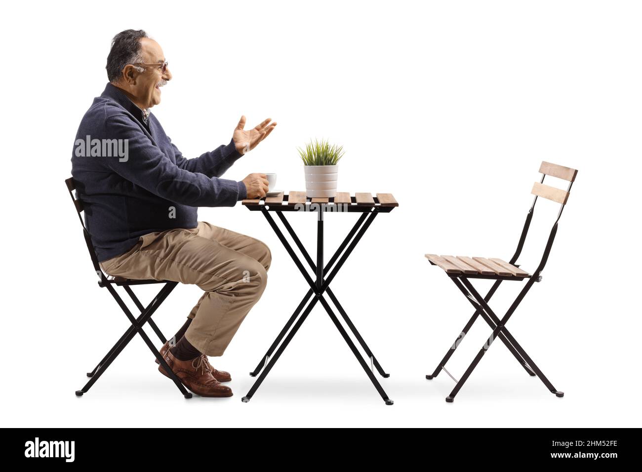 Profilo girato di un uomo maturo seduto in un caffè e gesturing con mano isolato su sfondo bianco Foto Stock
